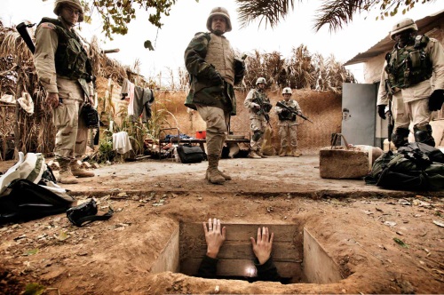 Yuri Kozyrev, A journalist climbs out of the hole where toppled dictator Saddam Hussein was captured in Ad Dawr. Iraq’s defeated leader raised his arms out of his 'rat hole' and said he was Saddam Hussein and that he wanted to negotiate, Iraq, December 15, 2003.